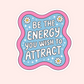 A die-cut sticker with a wavy scalloped border, featuring the motivational quote 'BE THE ENERGY YOU WISH TO ATTRACT' in white bubble letters on a light blue background with white daisies and sparkles. The sticker is presented on a solid pale pink background.