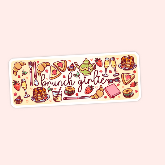 A rectangular sticker with rounded corners featuring a cute brunch-themed illustration. The design includes croissants, pancakes, strawberries, a teapot, champagne glasses, a sandwich, sunglasses, and the words 'brunch girlie' in script.