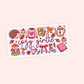 A rectangular sticker with rounded corners featuring a cute autumn-themed illustration and the words 'cozy girlie' in cursive. The design includes a hedgehog, sweater, journal, teapot, acorns, mushrooms, a hot cocoa cup, and bows on a pale pink background.