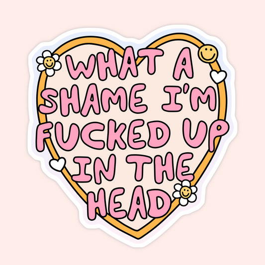 A die-cut sticker featuring a heart outline with the text 'WHAT A SHAME I'M FUCKED UP IN THE HEAD' in pink bubble letters, decorated with small smiling flowers and hearts on a pale pink background.