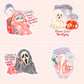 Four cartoon die-cut stickers arranged in a 2x2 grid on a pale pink background. The stickers feature horror-themed illustrations: a cat in a pink blanket with a ghost, a white ghost with a red rotary phone, Ghostface with a phone, and a goose holding a popcorn bucket and flashlight with text references to horror movies.