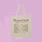 A cream-colored canvas tote bag with two handles, featuring a printed list titled 'The Great Divide: The Last of the Bugs' in brown text, set against a solid lavender background.