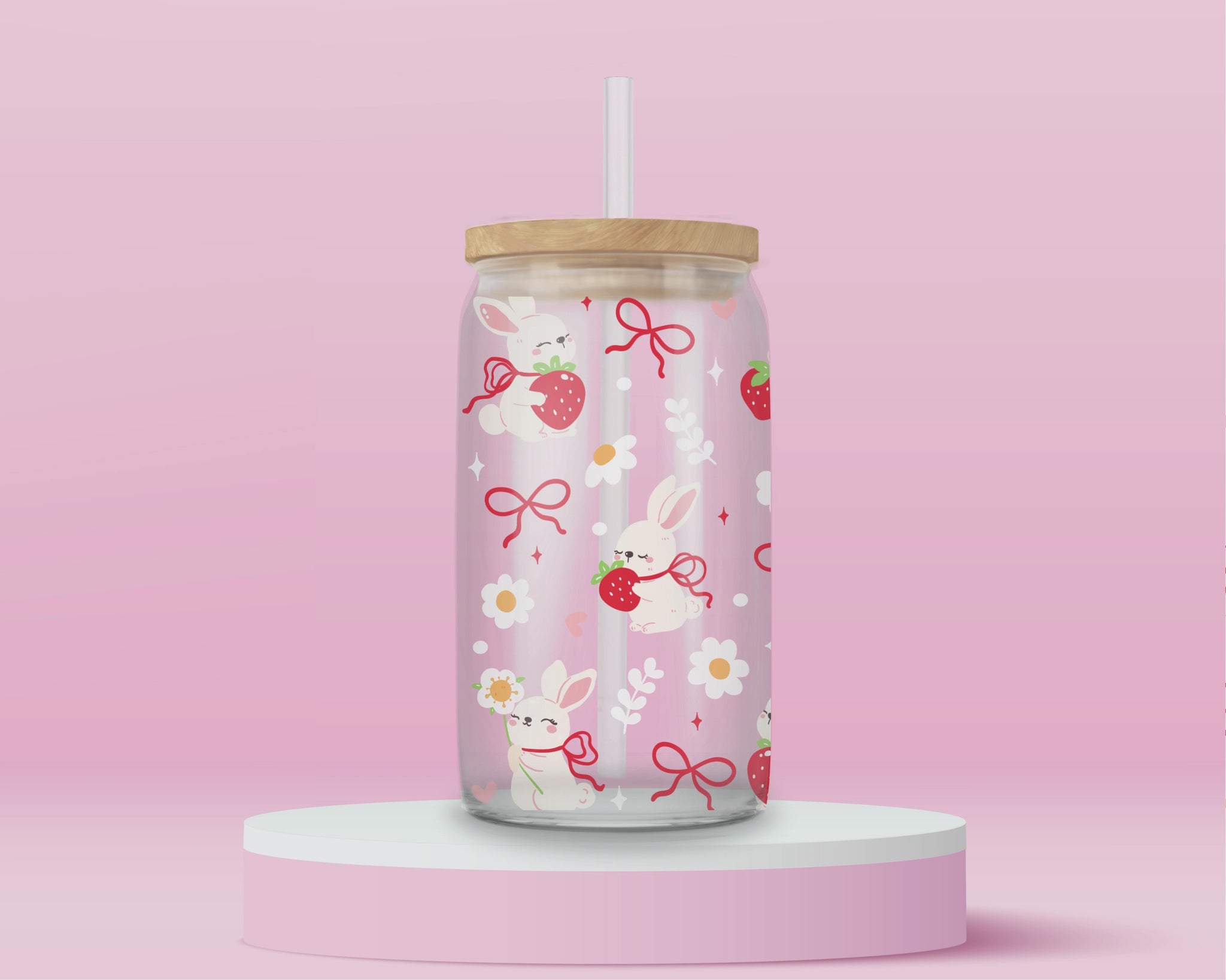 A sweet and soft glass cup covered in bunnies holding strawberries, red bows, white daisies, and hearts. Bunnycore perfection.