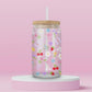 Clear glass can tumbler with a soft pink background, covered in cherries, strawberries, lemons, flowers, bows, and pastel doodles for a sweet garden-inspired look.