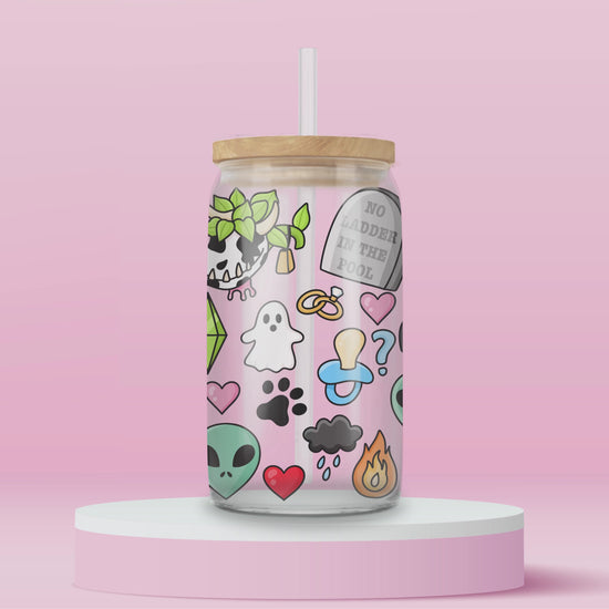 Glass cup with playful Sims-inspired icons including ghosts, plumbobs, gravestones that read “No Ladder in the Pool,” hearts, aliens, skull plants, and colorful objects.