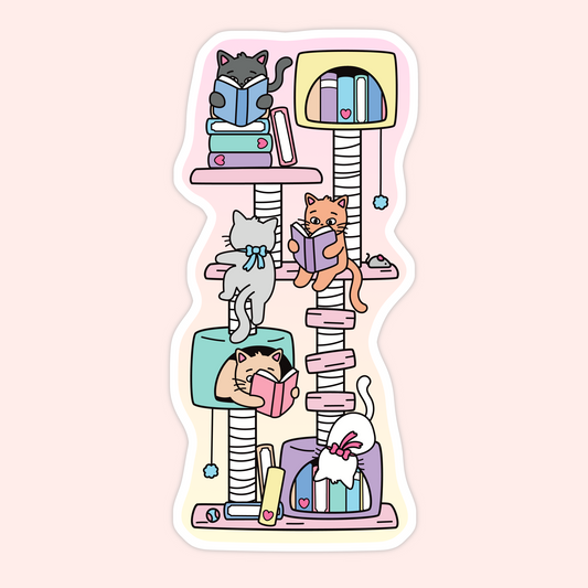 A die-cut sticker featuring a whimsical illustration of several cats reading books on a tall, pastel-colored cat tree. The sticker is shown against a soft pink background.