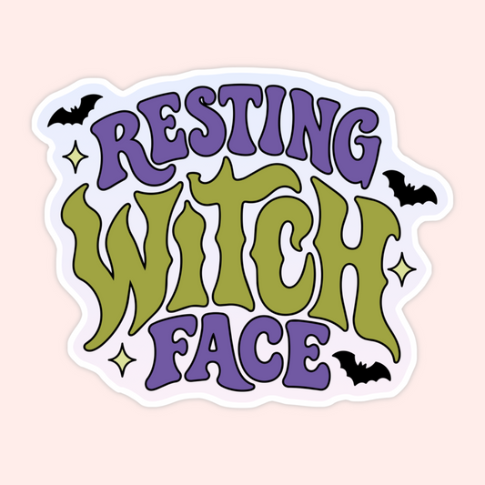 A die-cut sticker with the phrase 'RESTING WITCH FACE' in stylized purple and olive green lettering, decorated with small black bats and gold stars on a pale pink background.