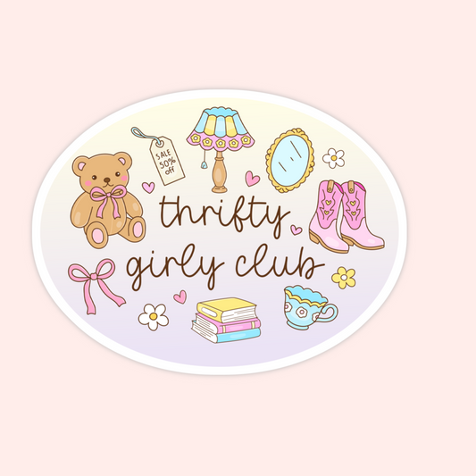 An oval sticker or decal featuring a western-themed 'Thrifty Girly Club' design on a pale pink background. The sticker illustration includes a teddy bear, cowboy boots, a lamp, a mirror, flowers, a stack of books, a teacup, and a pink bow.